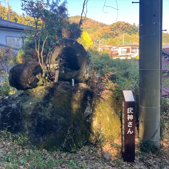 疣神さん｜穴の開いた大きな石（溶岩樹型）である。石の穴に溜まった水を疣につけて、家の敷居を跨ぐまで振り返らずに帰ると疣が取れるといわれた。